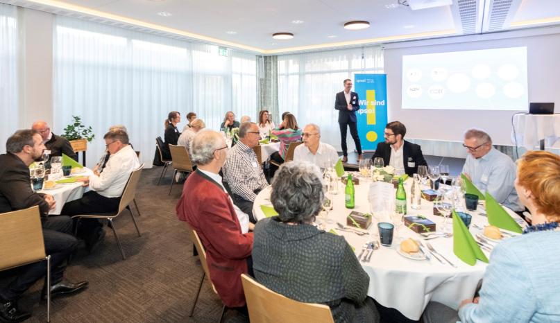 Sicht auf Saal mit allen Personen im Saal